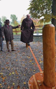 Wallfahrtspriester Raphael Fässler balanciert über das elastische Band, unterstützt von Kirchenratspräsident Jürg Grämiger.