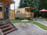 Ein Gast lehnt sich an die Veranda des Zirkuswagens, in dem vier Betten, Bad und Kochnische Platz haben. (Bild: Gudrun Enders)