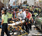 Rettungskräfte transportieren Verletzte ab, nachdem ein Auto in die Menschen raste. (Bild: Steve Helber/AP (Charlottesville, 12. August 2017))