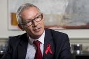 Martin Klöti in seinem Büro in St.Galler Regierungsgebäude - mit dem Red-Ribbon-Anstecker der Aids-Hilfe-Schweiz. (Bild: Keystone)