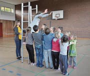 Eine Primarschülerin lässt sich in die rettenden Arme ihrer Gruppe fallen. In der Slapstick-Nummer hätte sie es von alleine nicht mehr von der Leiter runtergeschafft. (Bild: Simon Roth)