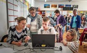 Jugendliche erklären Erwachsenen in der Schule Goldach das Spiel Finance Mission Heroes. (Bild: Michel Canonica)