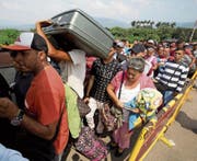 Venezolaner stehen auf der Grenzbrücke «Simon Bolivar» Schlange, um nach Kolumbien zu gelangen. (Bild: Fernando Vergara/AP (21. Februar 2018))