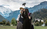 Eine Touristin mit Niqab in Interlaken macht ein Selfie mit einer Frau in Tracht. (Bild: Rolf Neeser/Keystone (Interlaken, 4. Oktober 2017))