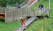 Buntes Treiben auf der Skisprungschanze Chollersweid in Wildhaus: Auch bei strömendem Regen erklimmen die einen die Stufen und freuen sich auf den bevorstehenden Flug, während der nächste Sportwoche-Teilnehmer bereits in der Anlaufspur ist. (Bild: Robert Kucera)