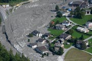 Die Luftaufnahme zeigt das Material des Felssturzes, das bis ans Dorf geschoben wurde. (Bild: GIAN EHRENZELLER (EPA KEYSTONE))