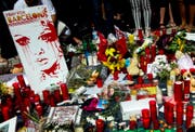 Vor dem Liceu Theater in Barcelona legen Passanten Blumen und Kerzen für die Opfer nieder. (Bild: QUIQUE GARCIA (EPA))