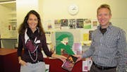 Markus Graf überreicht Bibliotheksmitarbeiterin Gabriela Knaus ein Exemplar des Luther-Romans «Durchs Feuer hindurch» von Richard Böck. Dieser hält heute eine Lesung in der Bibliothek. (Bild: gia)