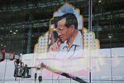 Arbeiter befestigen ein Porträt des verstorbenen thailändischen Königs Bhumibol am Flughafen der Hauptstadt Bangkok. (Bild: Keystone)