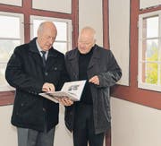 Autor Angelus Hux und Genossenschaftspräsident Urs Fankhauser blättern im Guggenhürli-Buch. (Bilder: Reto Martin)