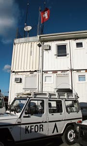 An den Fahnen ist zu erkennen, zu welchem Land die Container im KFOR-Camp Film City in Pristina gehören. (Bild: Katharina Brenner)