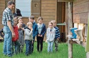 Imker Ernst Fuchs zeigt den Kindern die Einfluglöcher zu seinem Bienenhaus oberhalb des Golfplatzes in Lipperswil. (Bild: Mario Testa)