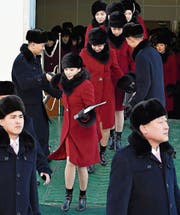Freiwillige Helfer auf den Zuschauerrängen der Gangneung Ice Arena, wo die Eiskunstlauf- und Shorttrack-Wettbewerbe durchgeführt werden (links). Ankunft der nordkoreanischen Cheerleader gestern in der südkoreanischen Hafenstadt Donghae. (Bilder: EPA)