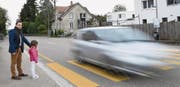 Petitionär Michele Sorice steht mit seiner Tochter Ilary am Fussgängerstreifen. Immer wieder halten Autos nicht an und rasen an den wartenden Kindern vorbei. (Bild: Manuel Nagel)