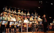 Die MG Niederhelfenschwil mit ihrem Dirigenten Marcel Eggler in ihrem Sommertenue. (Bild: Vroni Krucker)