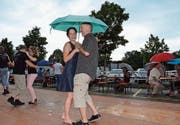 Tanzen macht auch mit Regenschirm Spass. Ein kurzer Regenschauer tat der Stimmung keinen Abbruch. (Bild: Christoph Heer)