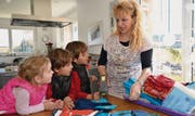Andrea Jucker legt die Kleider für die Börse bereit. Lenny und Jordan sowie Jamie (von rechts) möchten auch mithelfen. (Bild: Zita Meienhofer)