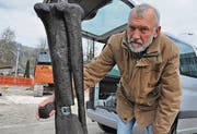 Urs Oberli zeigt das Bein des Dinos, das mit einem Barrenpfosten verstärkt ist.