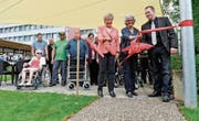 Der Jubiläumsweg ist eröffnet: Heidi Güttinger, Verwaltungsratspräsidentin der Genossenschaft Alterszentrum, die Landschaftsarchitektin Marianne Probst und Robert Gubser, technischer Leiter im Alterszentrum, beim Durchschneiden des Bandes. (Bild: Donato Caspari)