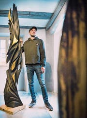Marco Sembinelli neben einer Holzskulptur von Urs Antoine Stöcklis, die er bemalt hat. (Bild: Andrea Stalder)