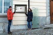 Gemeindeparlamentarier Samuel Curau und J&A-Aktuarin Anina Curau präsentieren einen möglichen Infoscreen-Standort am Rathaus. (Bild: PD)