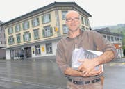 Kunsthallen-Präsident Roland Rüegg verteilt schon mal Plakate zur Kunstaktion. Im Hintergrund das Hotel-Restaurant Post in Ebnat-Kappel, wo das Kultur-Hotel im Juni eine Woche Gastrecht hat. (Bild: Hansruedi Kugler)