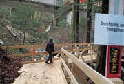 Unterhalb der dem Abbruch geweihten Brücke ermöglicht ab sofort ein Holzsteg das Überqueren des Eichenbachs. (Bild: Peter Eggenberger)