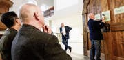 Gastprediger Klaus Douglass schaut zu, wie ein Gottesdienstbesucher eine eigene These an die Tür nagelt, die im Chor der Kirche aufgestellt wurde. (Bild: Donato Caspari)