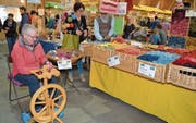 Elsbeth Feurer aus Wildhaus arbeitet am Spinnrad, während Mann Martin einer Kundin die Vorzüge naturgefärbter Wolle erklärt. (Bilder: Adi Lippuner)