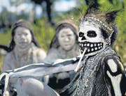 Vorchristliche Traditionen und Glaube an Magie: Eine als Skelett bemalte Frau raucht bei einem Ritual in Papua-Neuguinea. (Bild: getty/Eric Lafforgue)