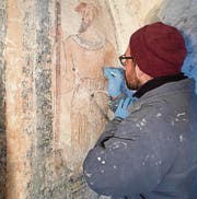 Restaurator Michael Hauser arbeitet am Bild des Kriegsknechts.