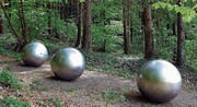 Die Gedenkstätte für die 71 Opfer des Flugzeugabsturzes vom 1. Juli 2002 in Überlingen besteht aus einer zerrissenen Perlenkette in Form von sieben grossen und kleinen Edelstahlkugeln, die an einem Waldrand an die Toten erinnert. (Bild: Keystone/Walter Bieri)