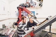 Die beiden Informatiker Marvin Gülzow und Thomas Lindemeier (rechts) begutachten das neuste Werk des Malroboters e-David. (Bild: Thi My Lien Nguyen)