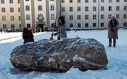 Die St. Galler Regierungsrätin Heidi Hanselmann befreit den Stein TO im Stiftsbezirk vom Schnee. (Bild: Kn.)
