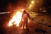 Ein Gefängnismitarbeiter verbarrikadiert während einer Demonstration den Zugang zur Haftanstalt. (Bild: Thibault Camus/AP (Fresnes, 16. Januar 2018))