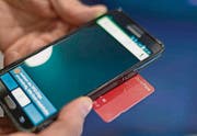 Um den Swisspass überprüfen zu können, ist ein spezielles Smartphone vonnöten. (Bild: GAETAN BALLY (KEYSTONE))