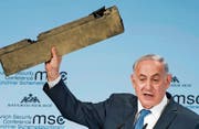 Der israelische Ministerpräsident Benjamin Netanjahu hält während seiner Rede ein Teil einer abgeschossenen iranischen Drohne in die Luft. (Bild: EPA (München, 18. Februar 2018))