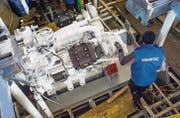 Ein Mitarbeiter der Luzerner Schiffbau-Firma Shiptec begutachtet den neuen Dieselmotor. (Bild: Reto Martin)