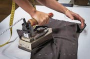 Mit dem sechs Kilogramm schweren Bügeleisen «dressiert» Eva Bräutigam die Anzughose in ihre Passform. (Bild: Reto Martin (Reto Martin))