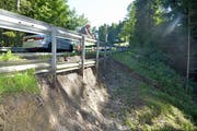 Schönholzerswilens Gemeindepräsident Fredy Oettli betrachtet das Ausmass des Schadens, den der Hangrutsch angerichtet hat. Am Montag fuhren auf der Strasse noch Autos, ab Dienstag ist sie komplett gesperrt. (Bild: Mario Testa)