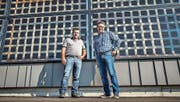 Karl Streule (links) und Daniel Eugster vor dem preisgekrönten Neubau, an dessen Fassade «lichtdurchlässige» Solarzellen haften. (Bild: Jil Lohse)
