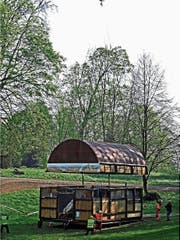 An einem sehr langen Seil senkt der Heli die Cabane-Teile zwischen hohen Bäumen im Warteggpark aufs Fundament. (Bild: Fritz Bichsel)
