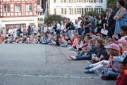 Gespannt sitzen die Kinder vor dem Schulhaus Kirchplatz in Wil. (Bild: Yves Weibel)