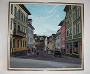 Auch Karl Peterlis Bild der Toggenburgerstrasse schmückt eine Wand in der Praxis am Klosterweg. Links ist des Künstlers Elternhaus – das Restaurant Sonne – zu sehen. Im Fluchtpunkt ist das ehemalige Haus Schmidweber abgebildet. Dort, wo sich die Praxis am Klosterweg heute befindet. (Bilder: Ursula Ammann)