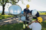 Ein Lehrling demontiert unter fachkundiger Hilfe einen Beleuchtungskörper; dieser wird einen neuen Masten erhalten. (Bild: pd)