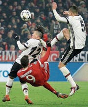 Münchens Doppeltorschütze Robert Lewandowski (rot) behauptet den Ball gegen Pepe (rechts) und Gary Medel. (Bild: Roland Wittek/EPA)