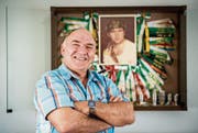 Ernst Gähwiler vor seinem Kranzkasten. Auf dem Bild im Hintergrund ist er in jüngeren Jahren zu sehen. (Bild: Reto Martin)