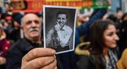 Während Selahattin Demirtas vor Gericht aussagt, hält ein Anhänger vor dem Gerichtsgebäude in Istanbul ein Bild des HDP-Chefs hoch. (Bild: Ozan Kose/AFP (12. Januar 2018))