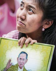 Eine Thailänderin in Trauer über den Tod ihres Königs. (Bild: Diego Azubel/EPA)