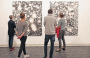 Ein Blick ins Weltall im Bauch des Thurgauer Kunstmuseums: Staunende Besucher vor den Aquarellen Helmut Wenczels. (Bild: Donato Caspari)